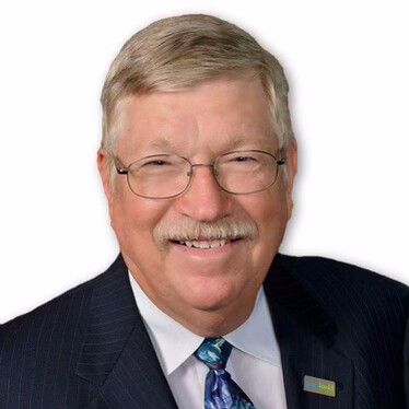 Smiling man wearing glasses and a suit.